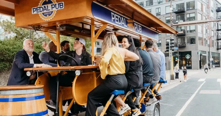 Group riding a Pedal Pub bike through the city