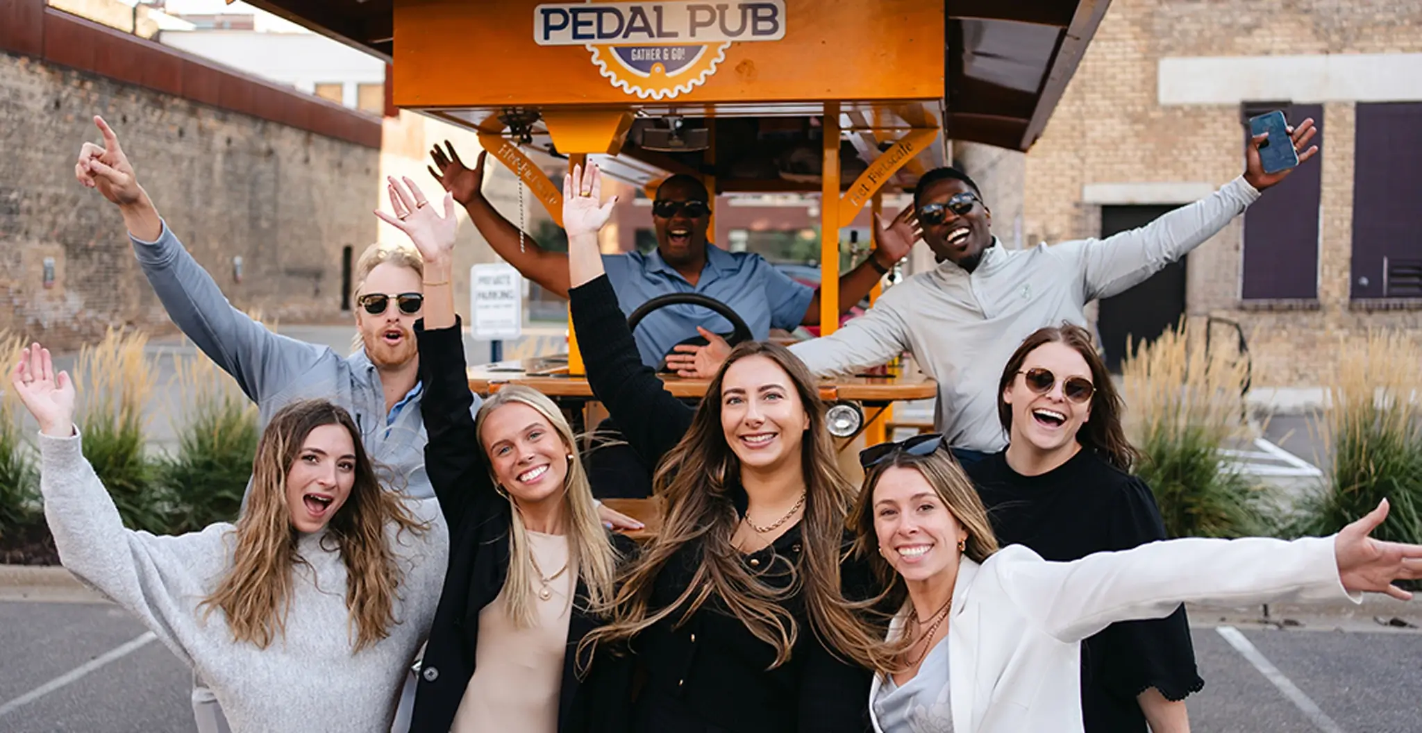 A group of happy guests celebrating on a Pedal Pub party bike